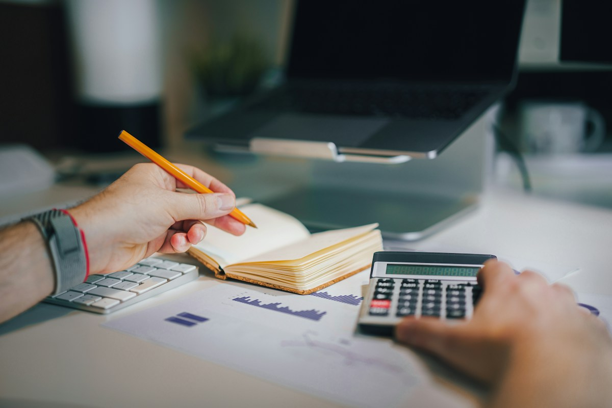 Accountant working with calculator and records