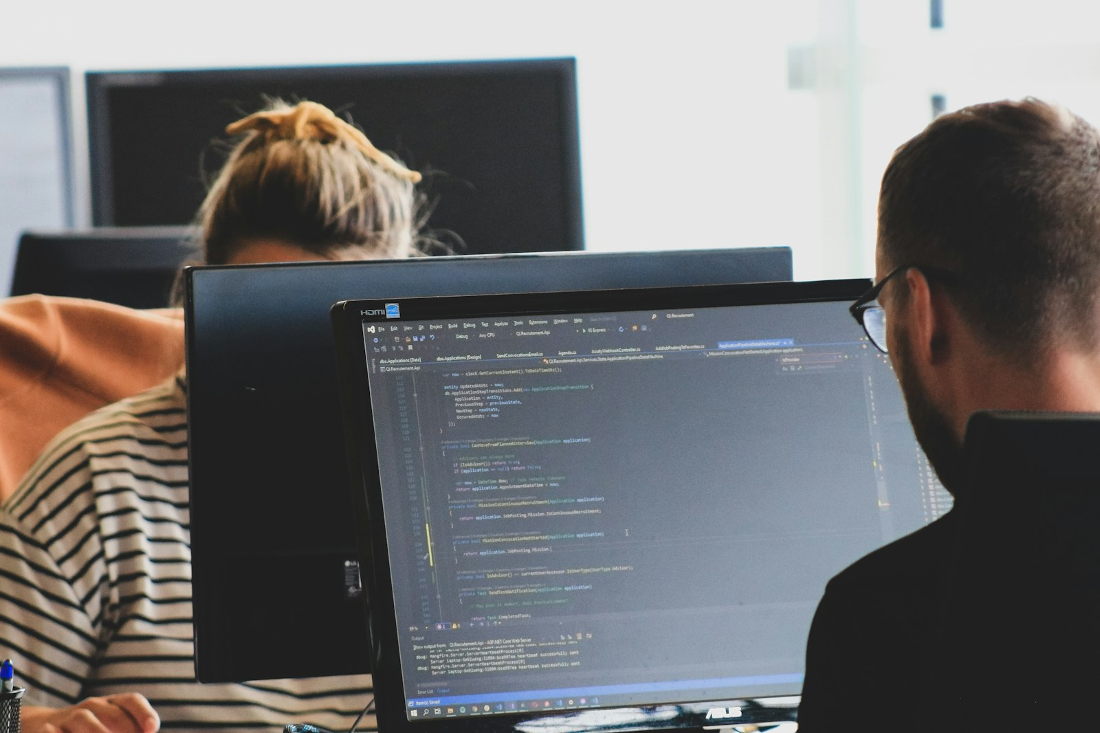 Dedicated Web Developer coding at dual workstations